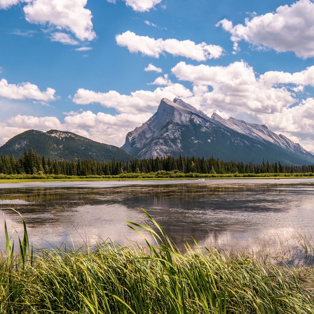 Красивое горное озеро под голубым небом с белыми облаками