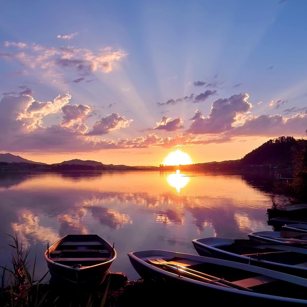 Лодки на берегу озера на закате солнца