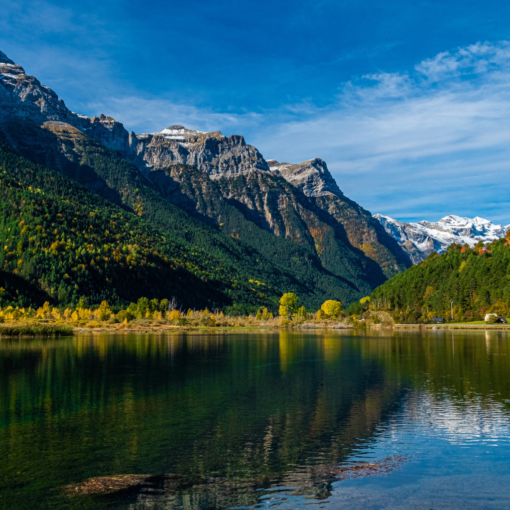 Холодная вода в чистом озере у горы под голубым небом