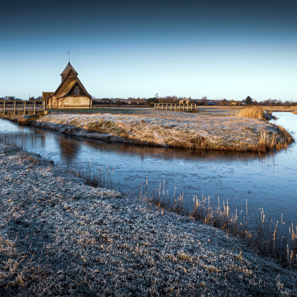 Иней покрывает землю холодным утром у реки