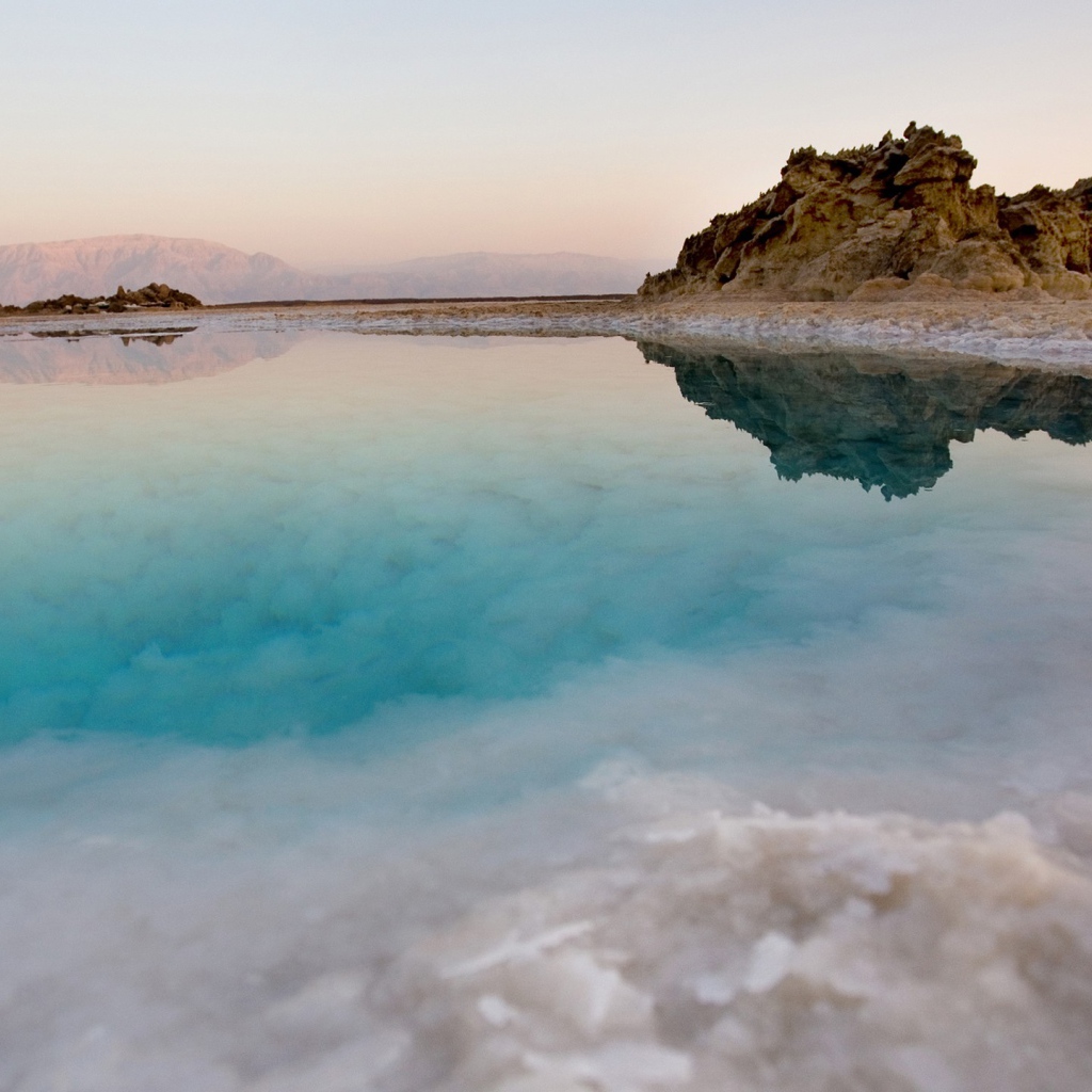 Покрытые льдом берега горного озера с голубой водой