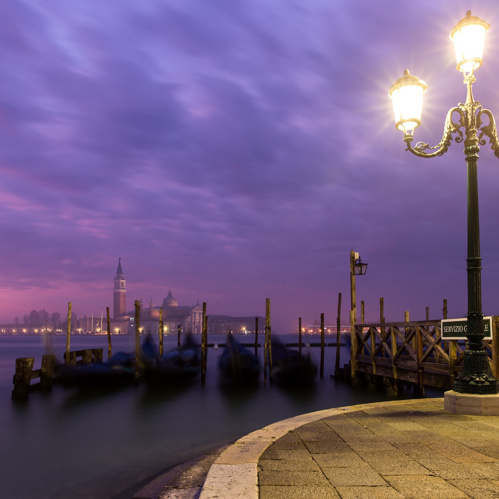 Зажженный фонарь на берегу реки ночью 