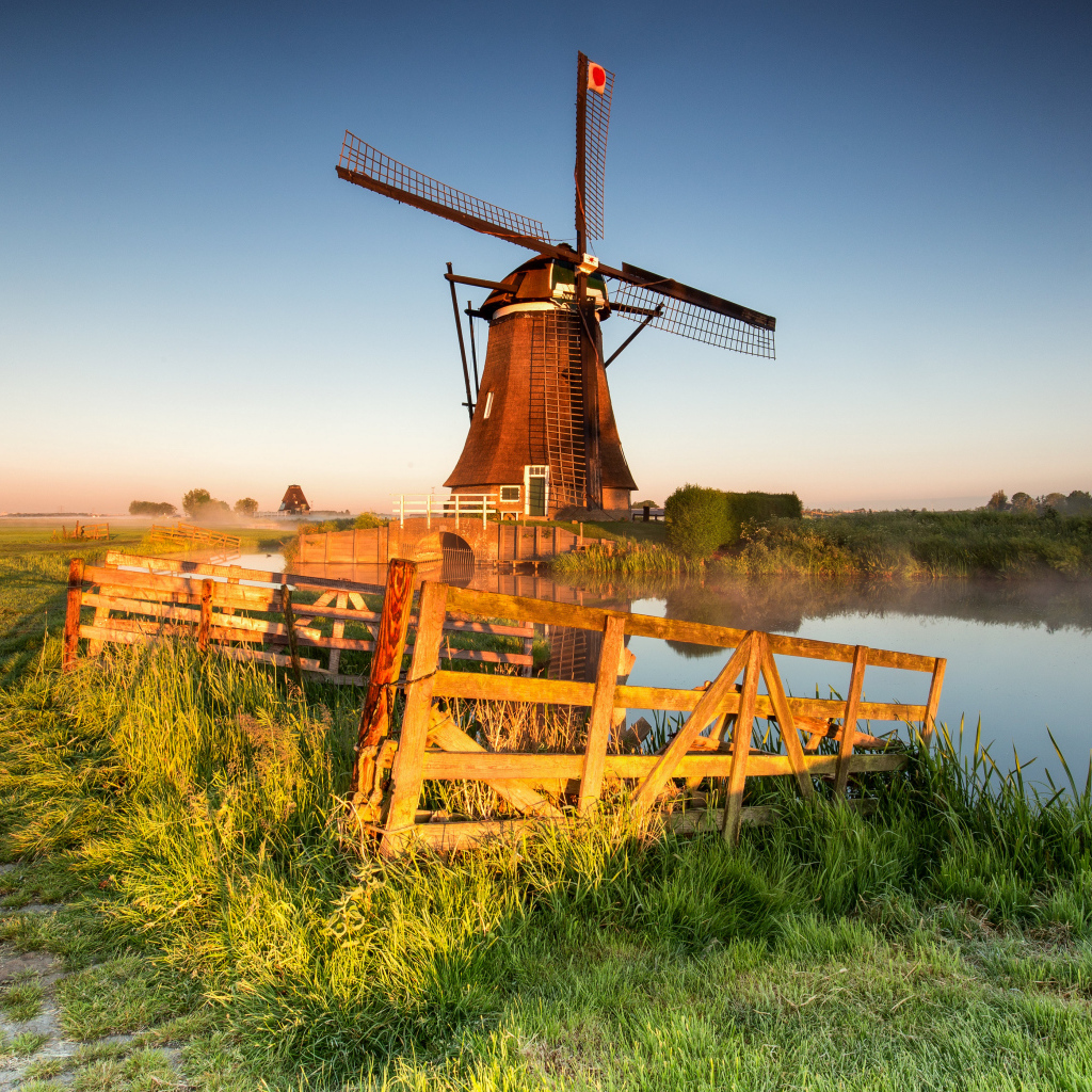 Старая мельница на берегу озера на ферме 