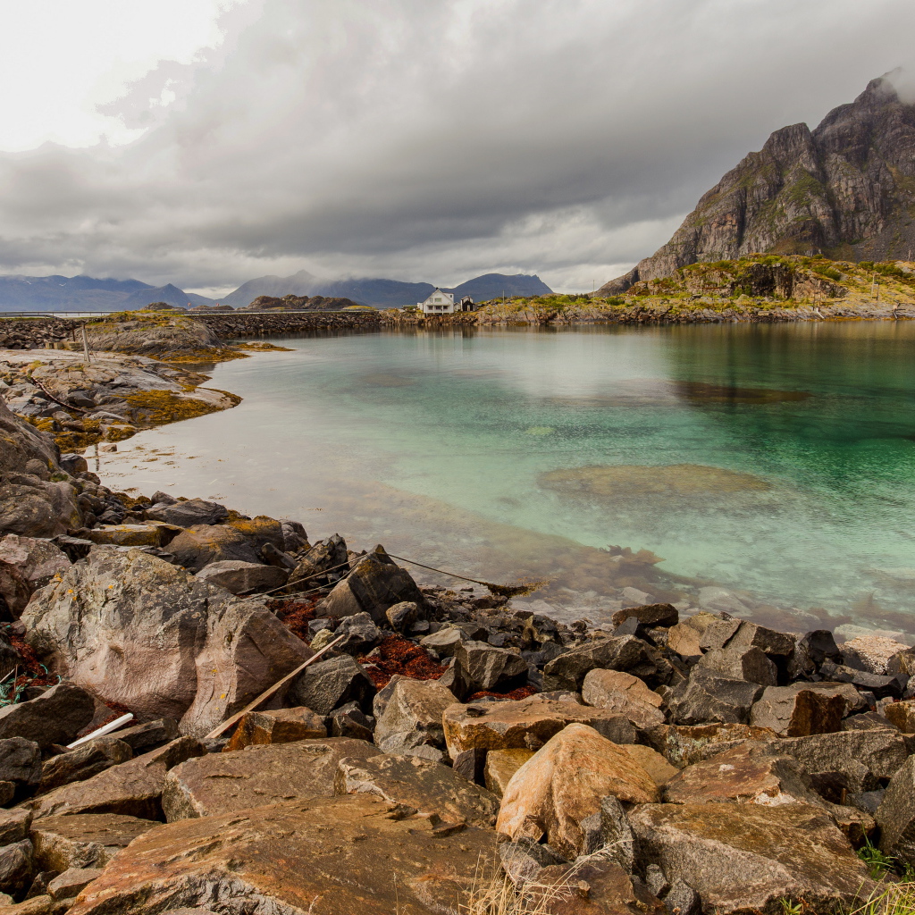 Камни на берегу горного озера под грозовым небом