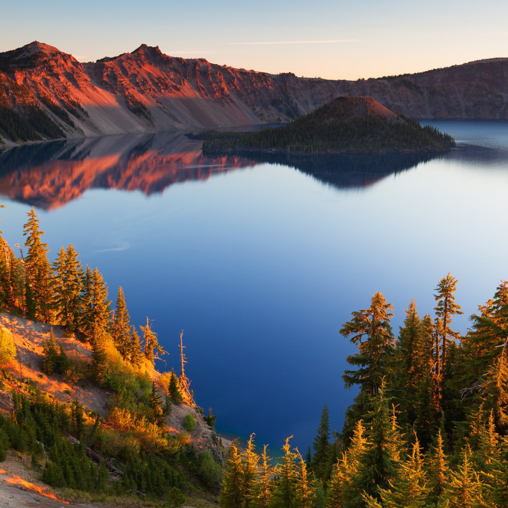 Небо отражается в горном озере в лучах солнца