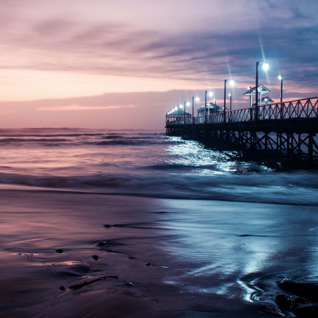 Вид на мост в океане с включенными фонарями ночью