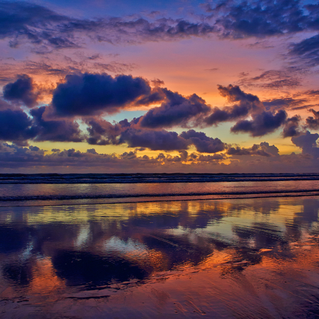 Черные тучи отражаются в морской воде на закате