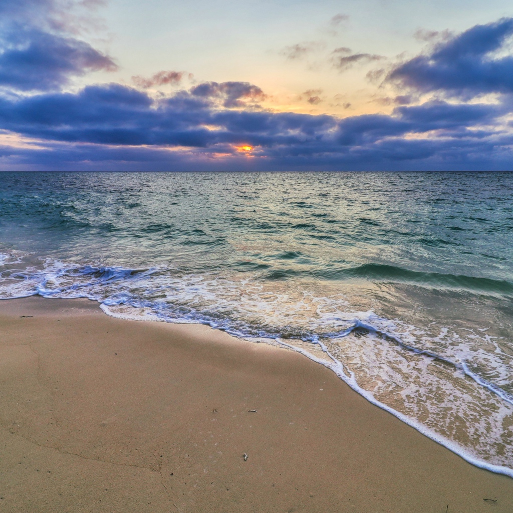 Голубая морская вода на песке на закате солнца