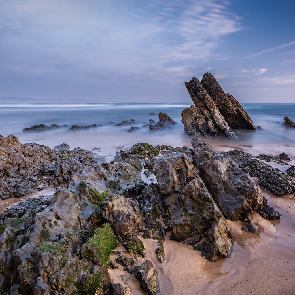 Туман над холодным утренним морем с камнями на берегу 
