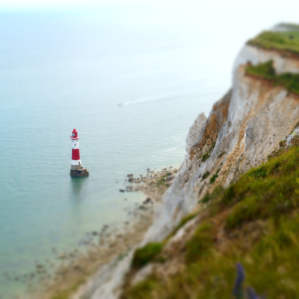 Lighthouse in the water at a cliff in the sea