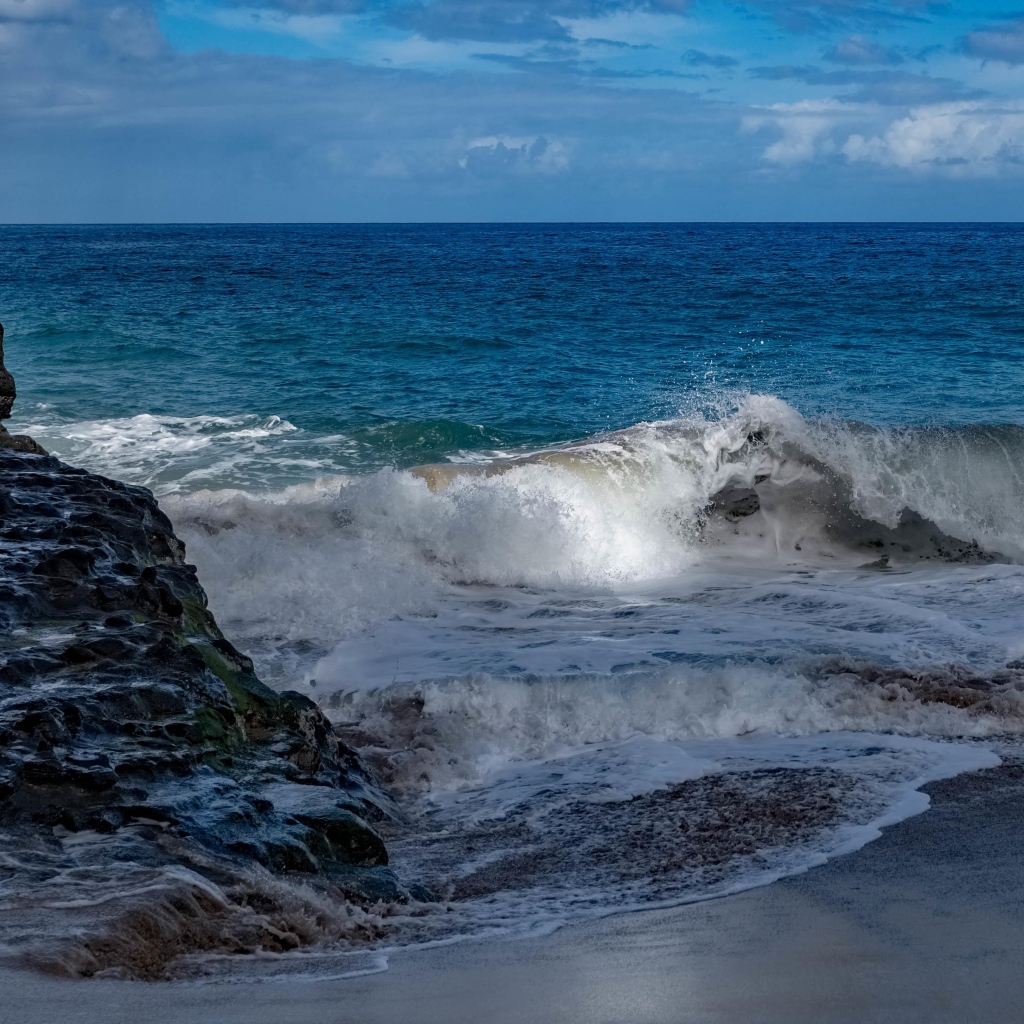 Бушующие белые волны в море у скал 