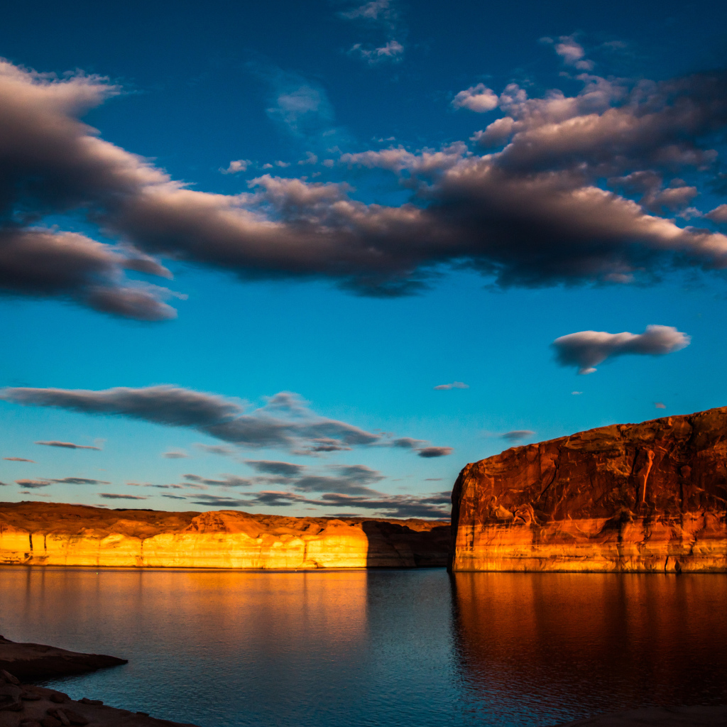 Скалы  в воде под голубым небом с облаками 