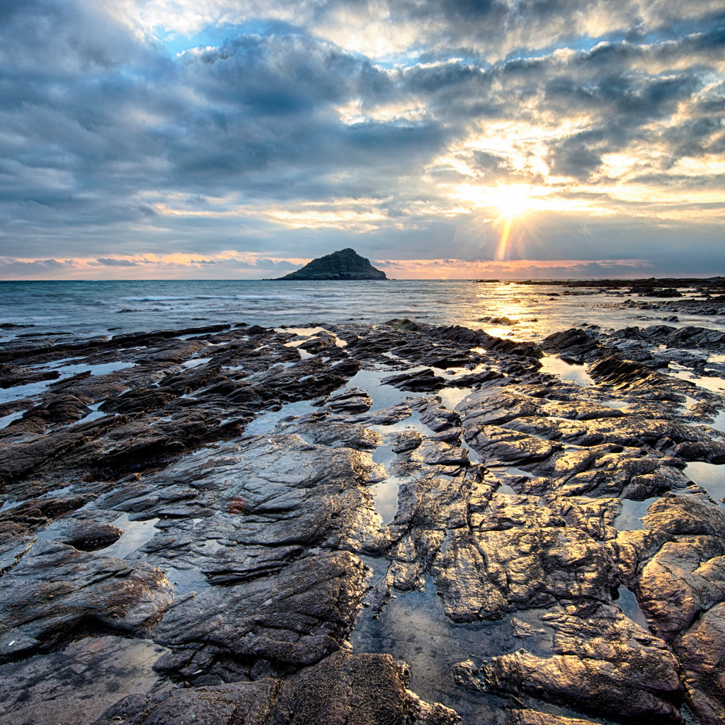 Каменный берег океана в лучах солнца