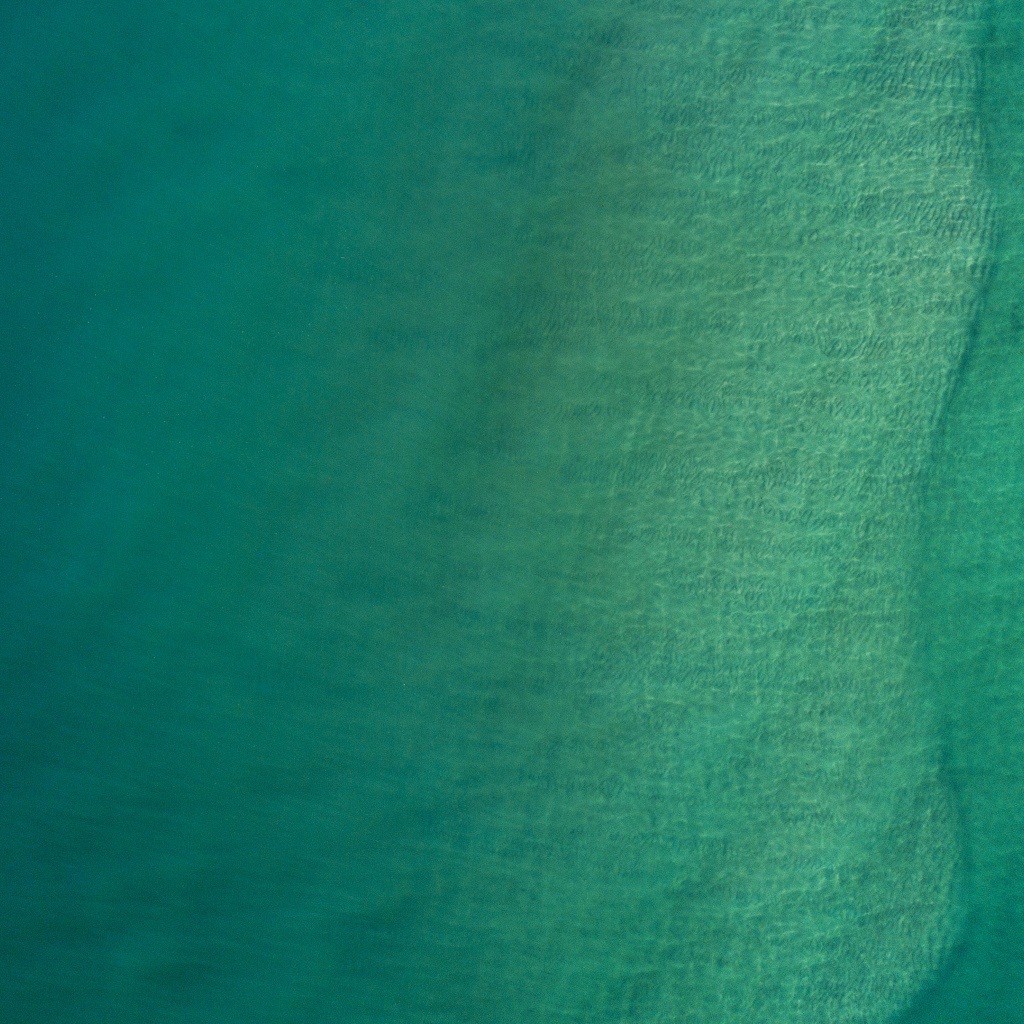 Вид сверху на спокойную голубую гладь океана