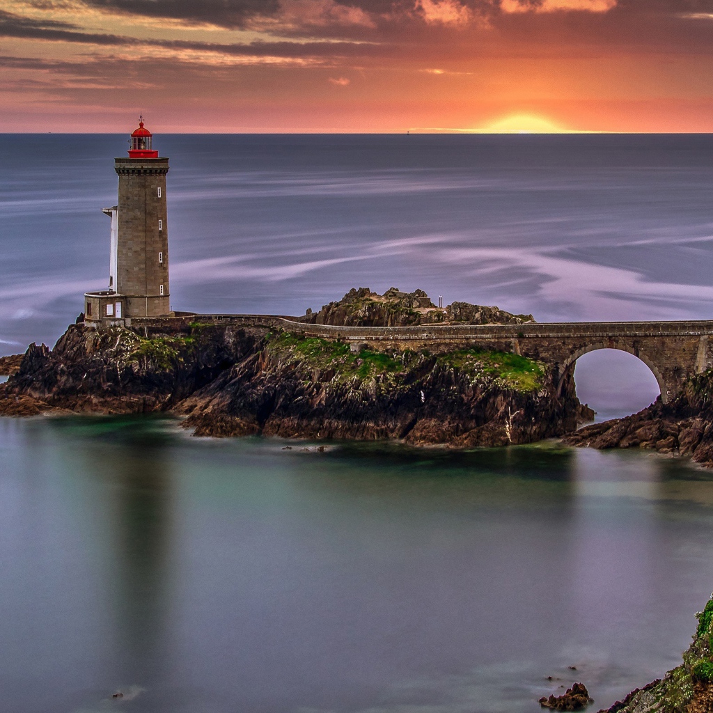 Вид на спокойное море и маяк на закате солнца 