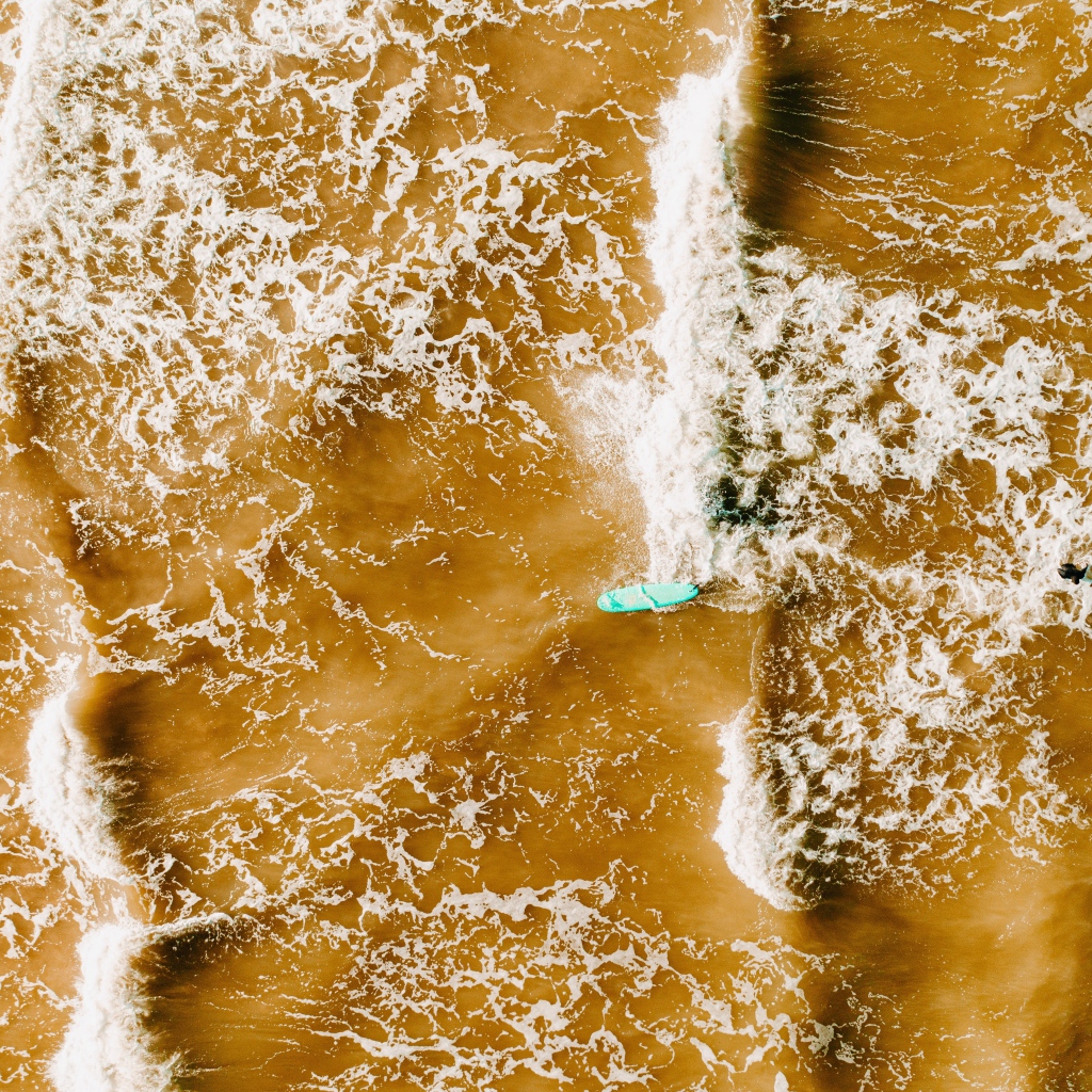 Белые волны на воде поднимают песок