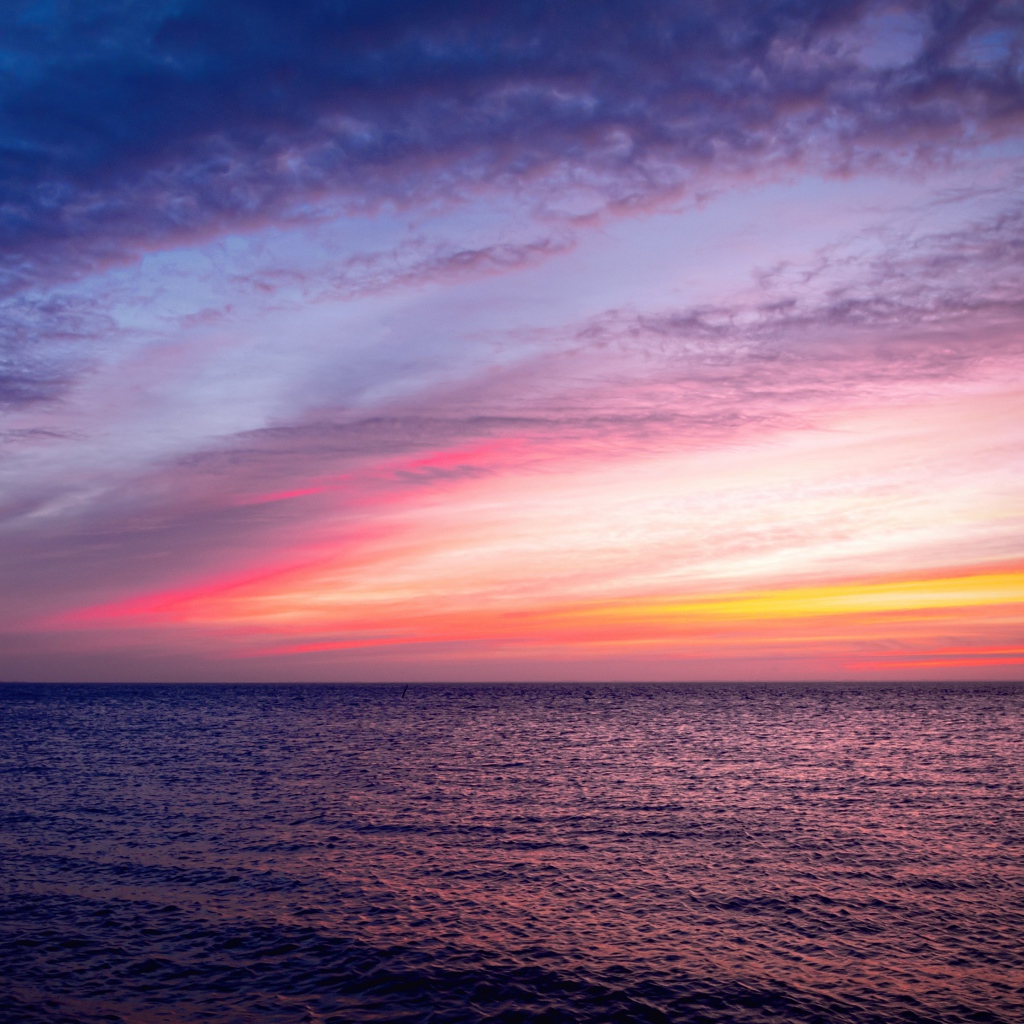 Красивый розовый закат в небе над тихим морем