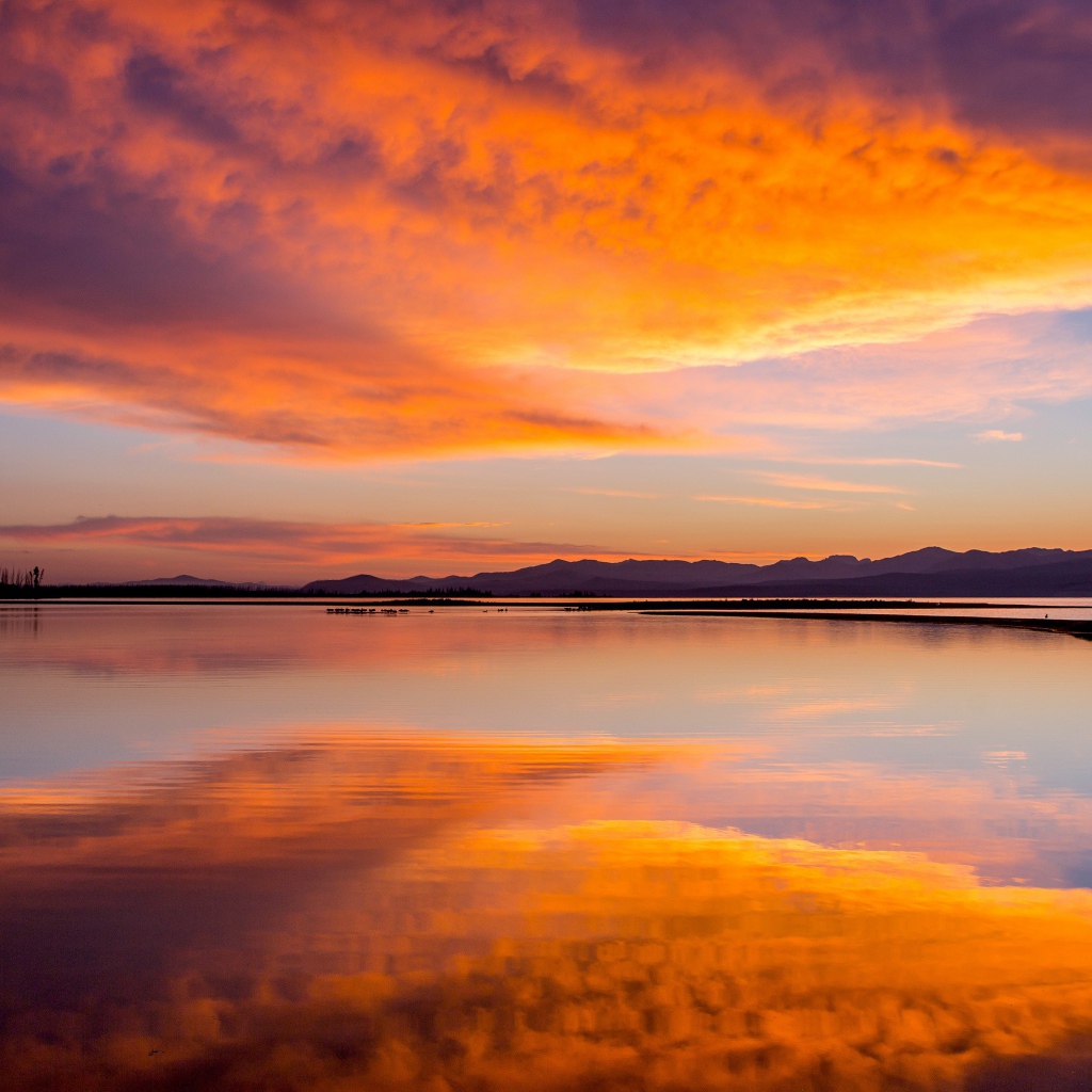 Красивое небо на закате отражается в спокойной воде озера