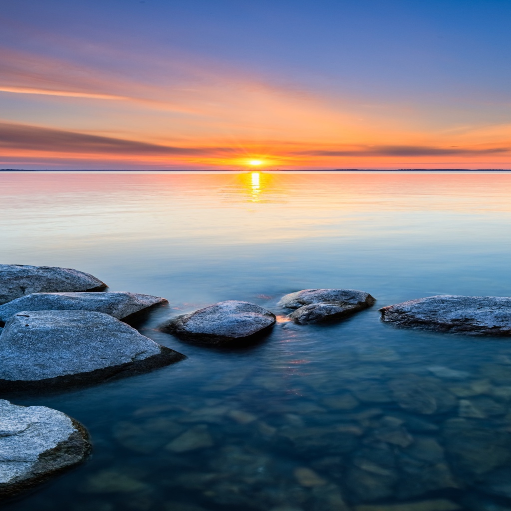 Большие камни в воде на закате яркого летнего солнца 