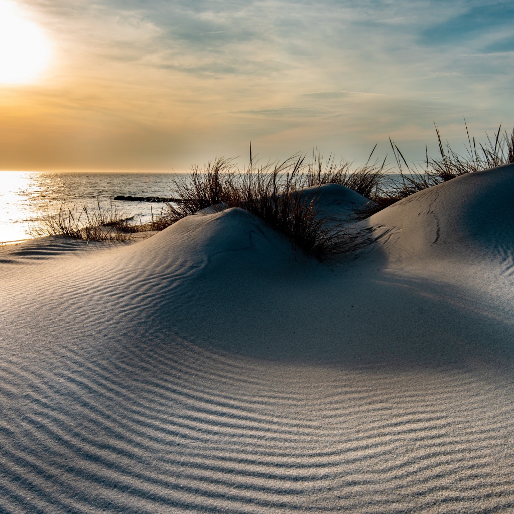 Горячий песок на берегу моря на закате 