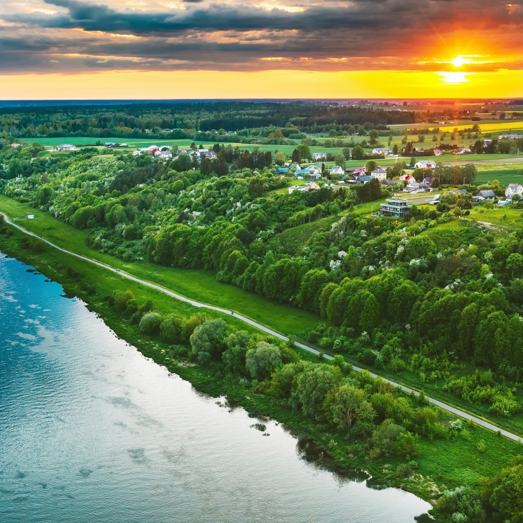 Закат солнца над городом у реки, вид с высоты 