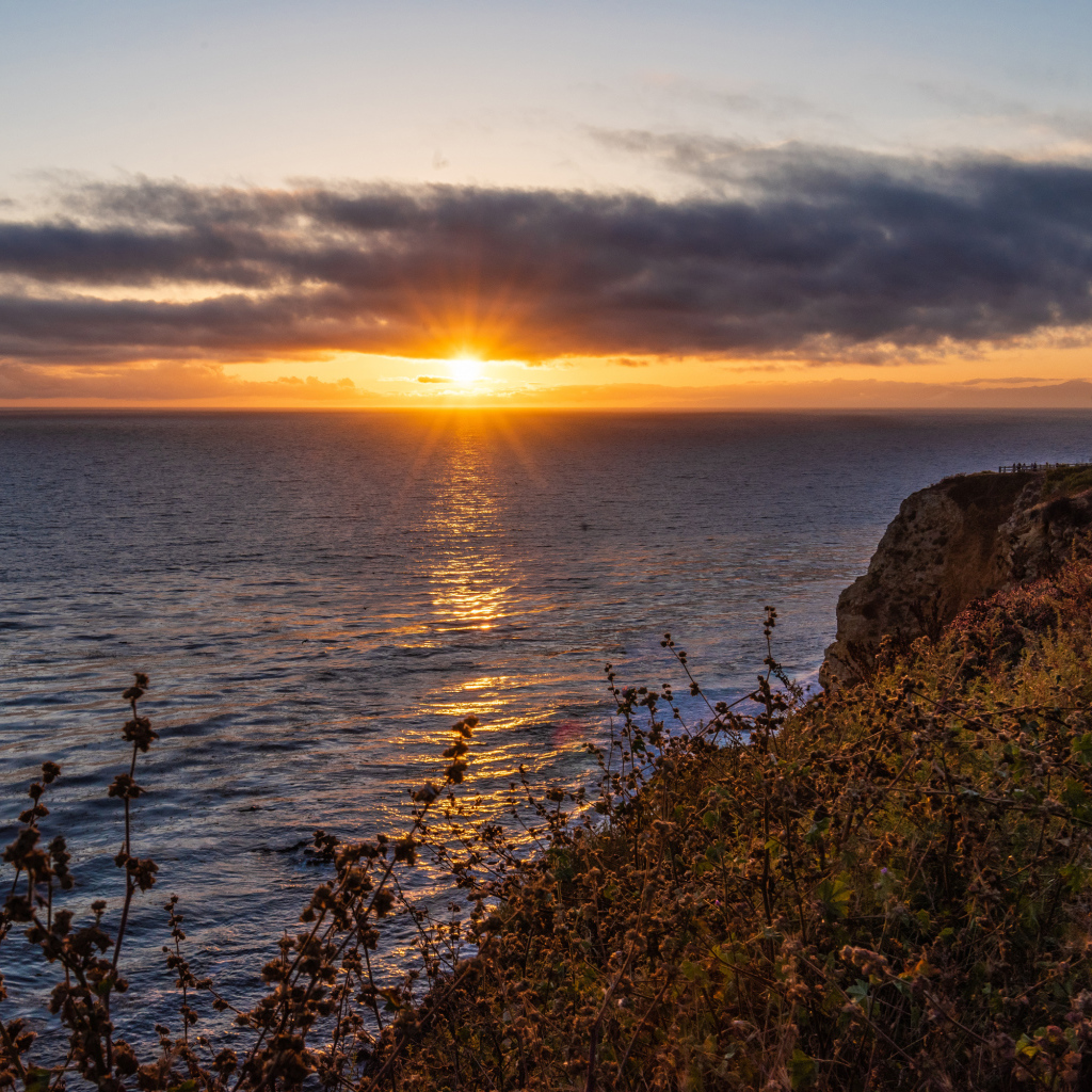 Вид на закат солнца в темных облаках в небе над морем 