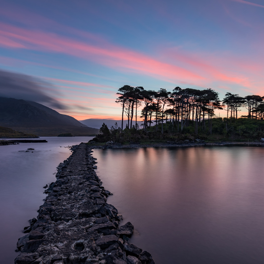 Дорога ведет к острову на фоне голубого заката