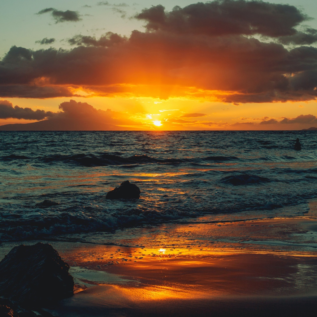 Мокрый песок на берегу океана на закате