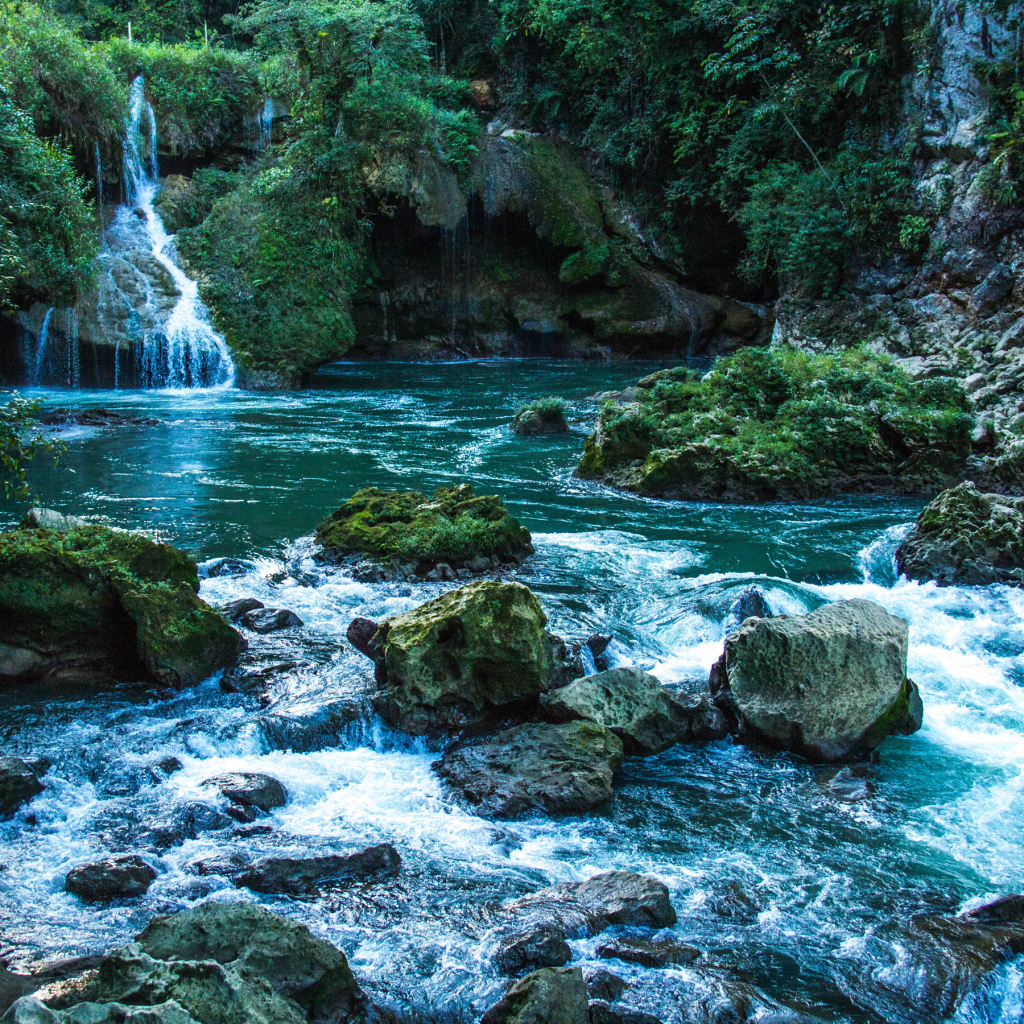 Голубая вода в водопаде стекает по камням 