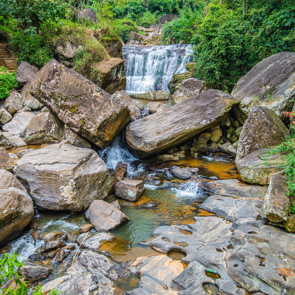 Лесной водопад стекает по огромным камням
