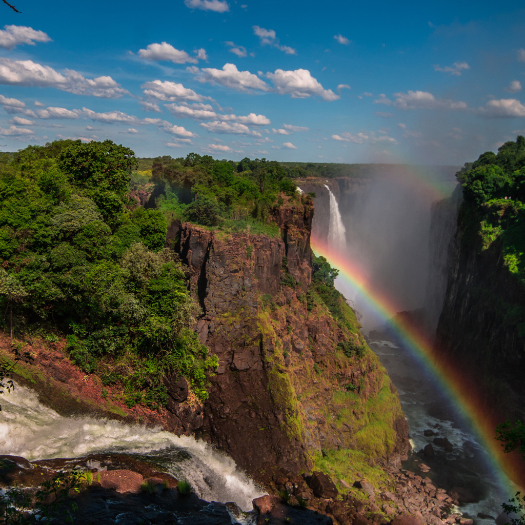 Радуга над водопадом на утесе 