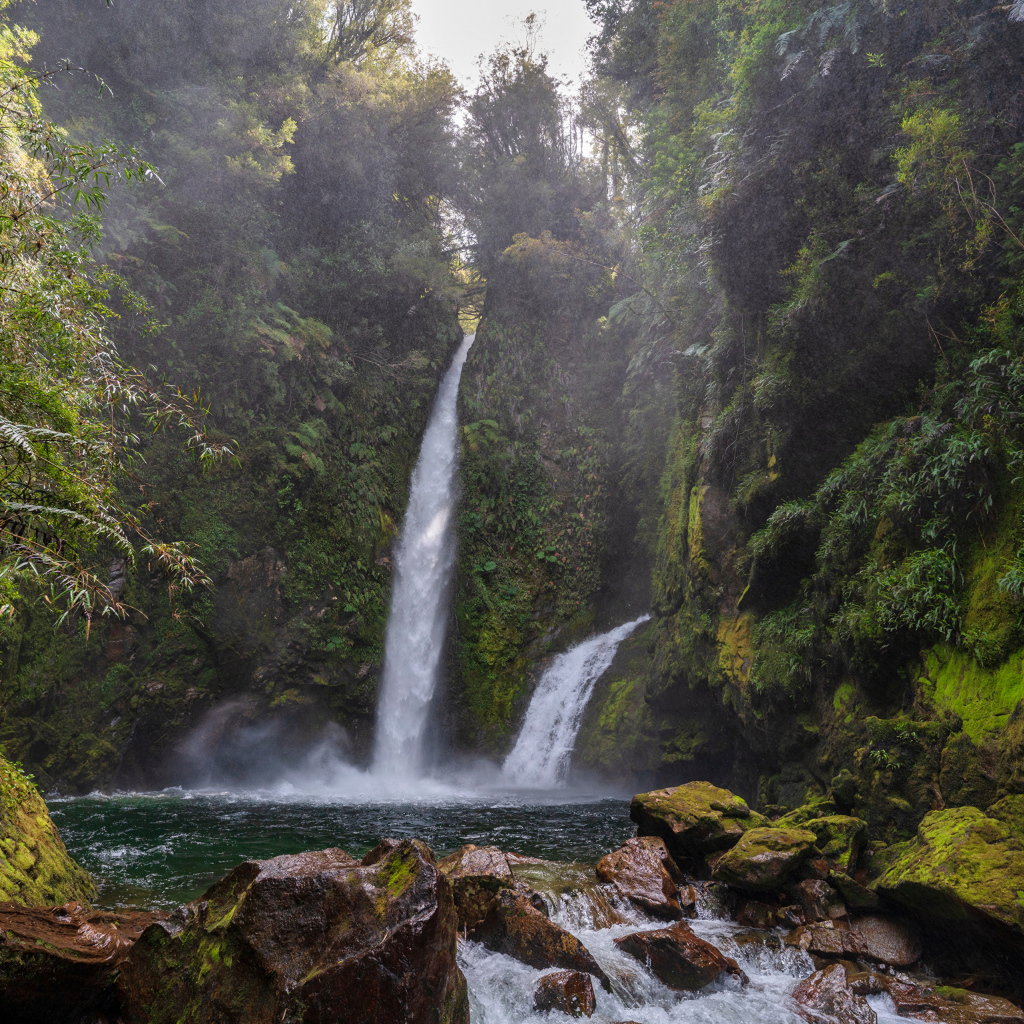 Водопад стекает со скалы в горную реку