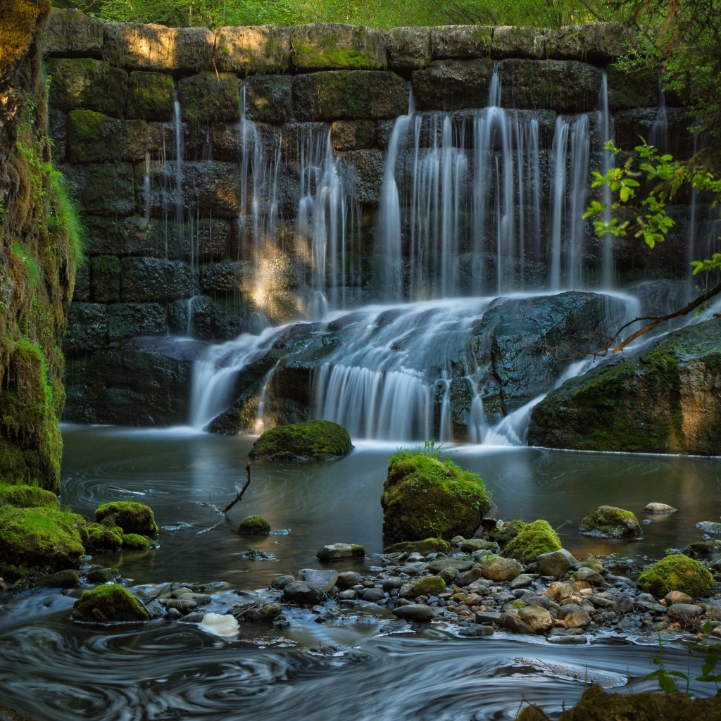 Водопад пробивается сквозь покрытые мхом камни 