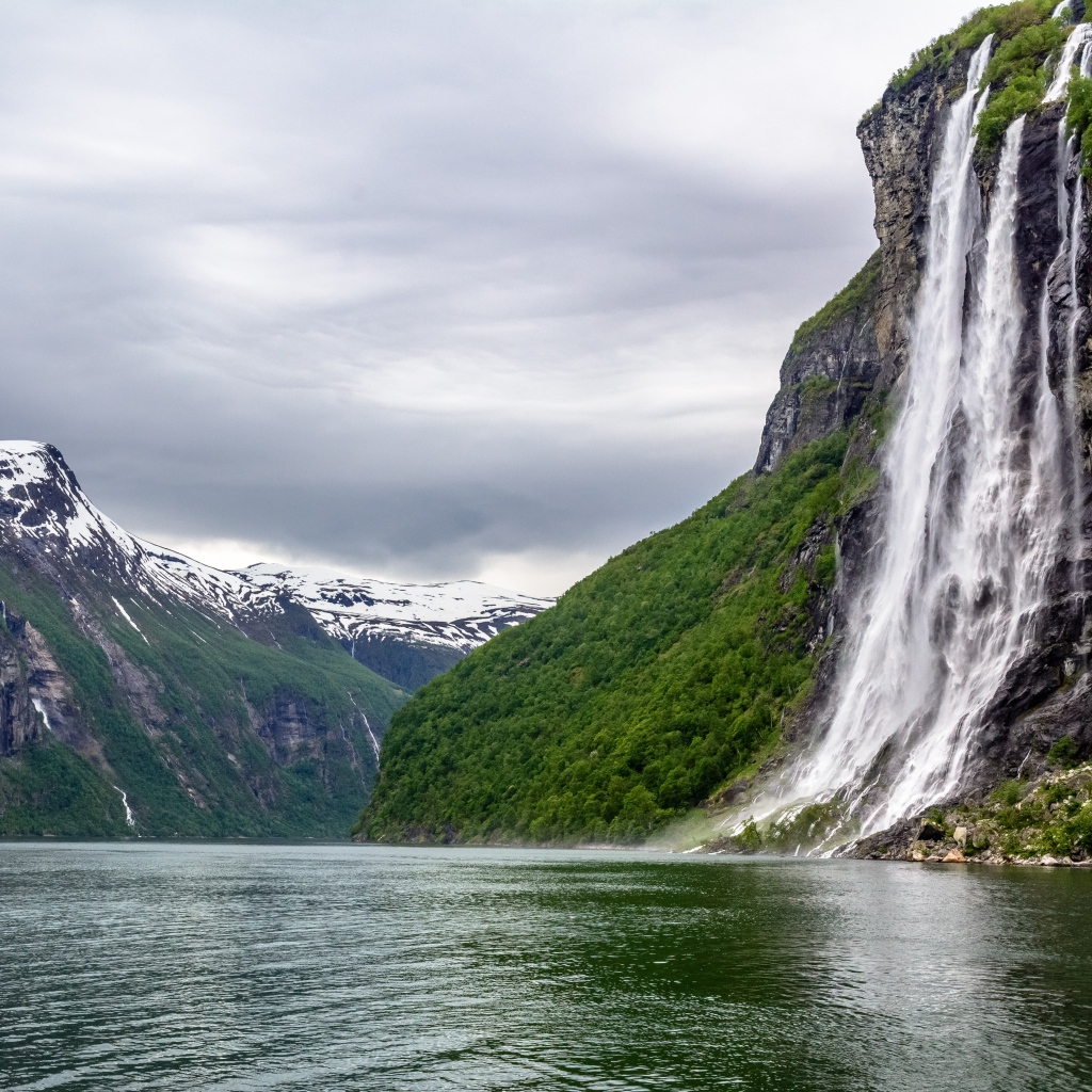 Водопад стекает с утеса в озеро, Норвегия