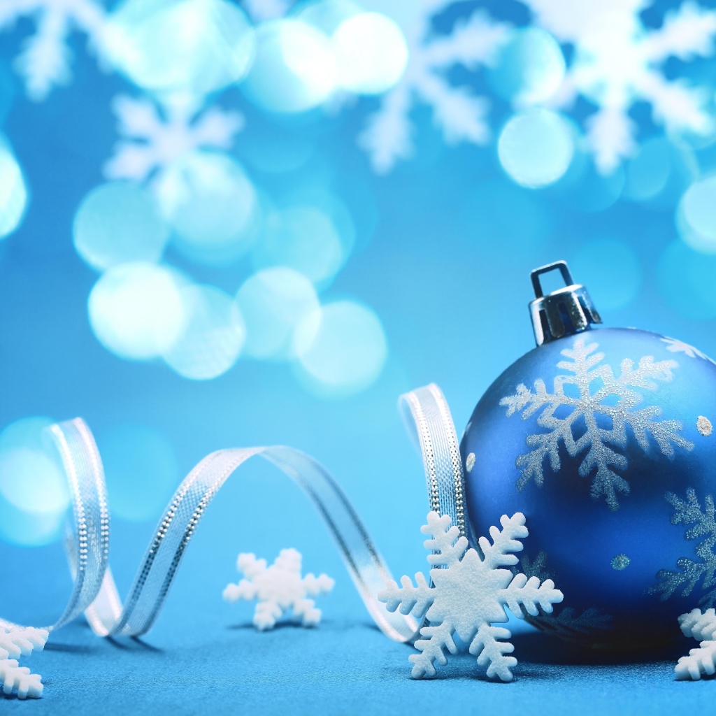 Красивый синий елочный шар с лентой и снежинками на Новый год 