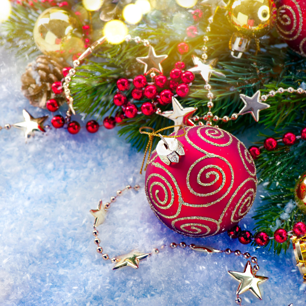 Яркие елочные украшения на снегу с веткой 