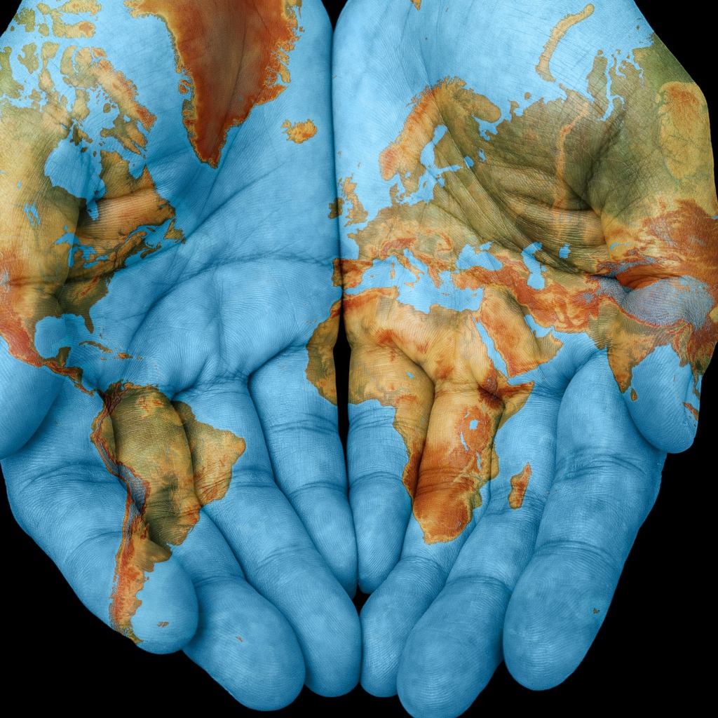 Руки с картой мира на черном фоне 