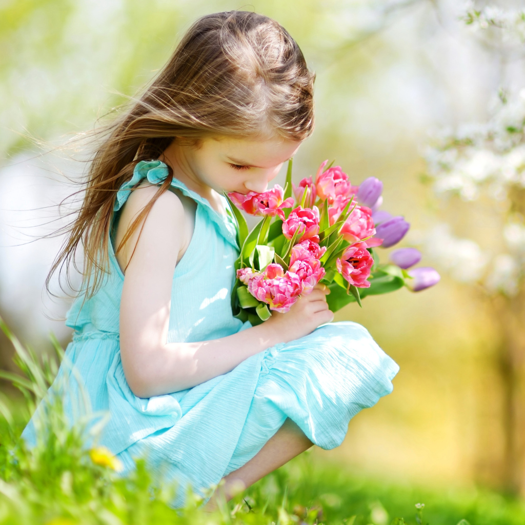 Красивая девочка в голубом платье с букетом тюльпанов