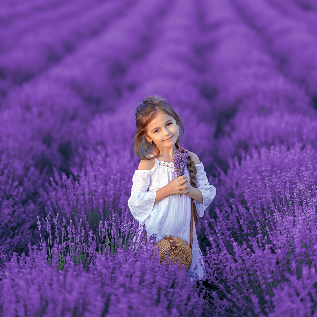 Красивая маленькая девочка на лавандовом поле 