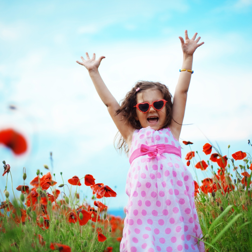 Счастливая маленькая девочка в платье на поле с маками