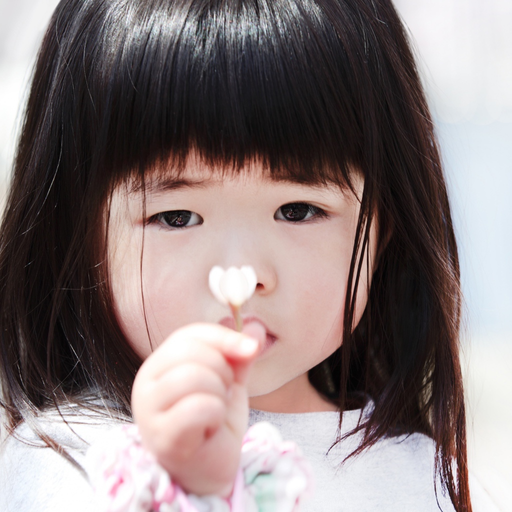 Маленькая девочка азиатка с цветком