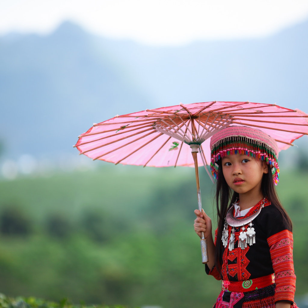 Маленькая девочка азиатка с розовым зонтом