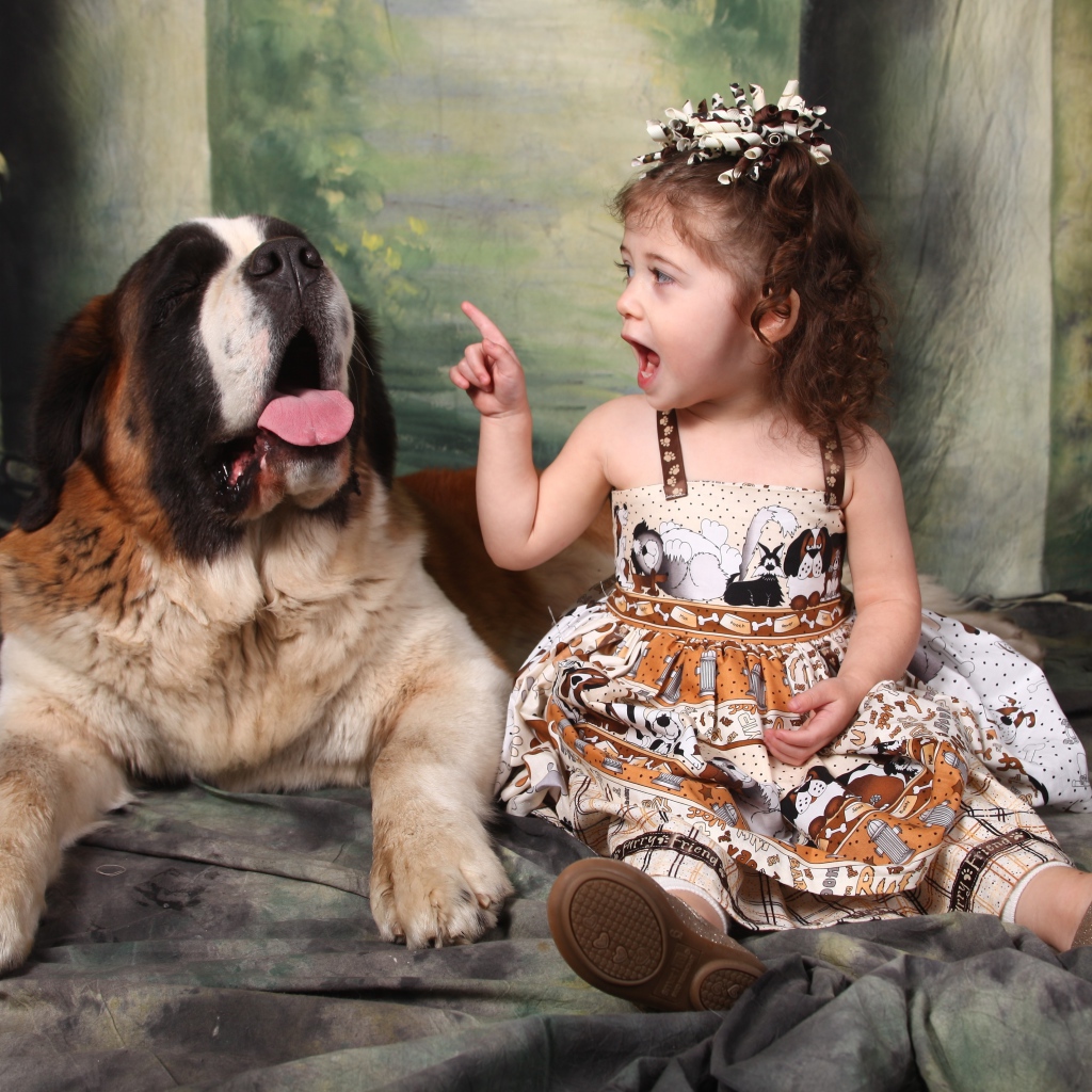 Маленькая красивая девочка с собакой породы сенбернар