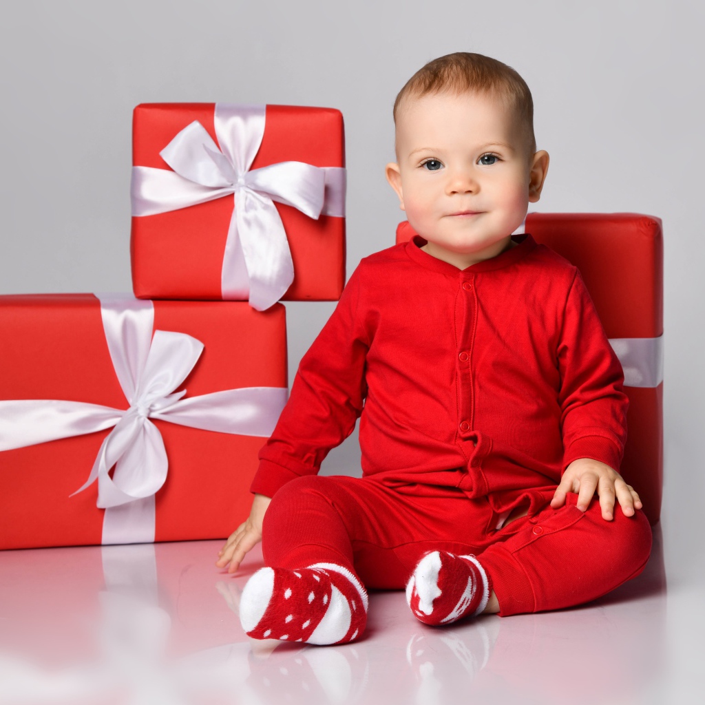 Маленький мальчик в красном костюме с подарками