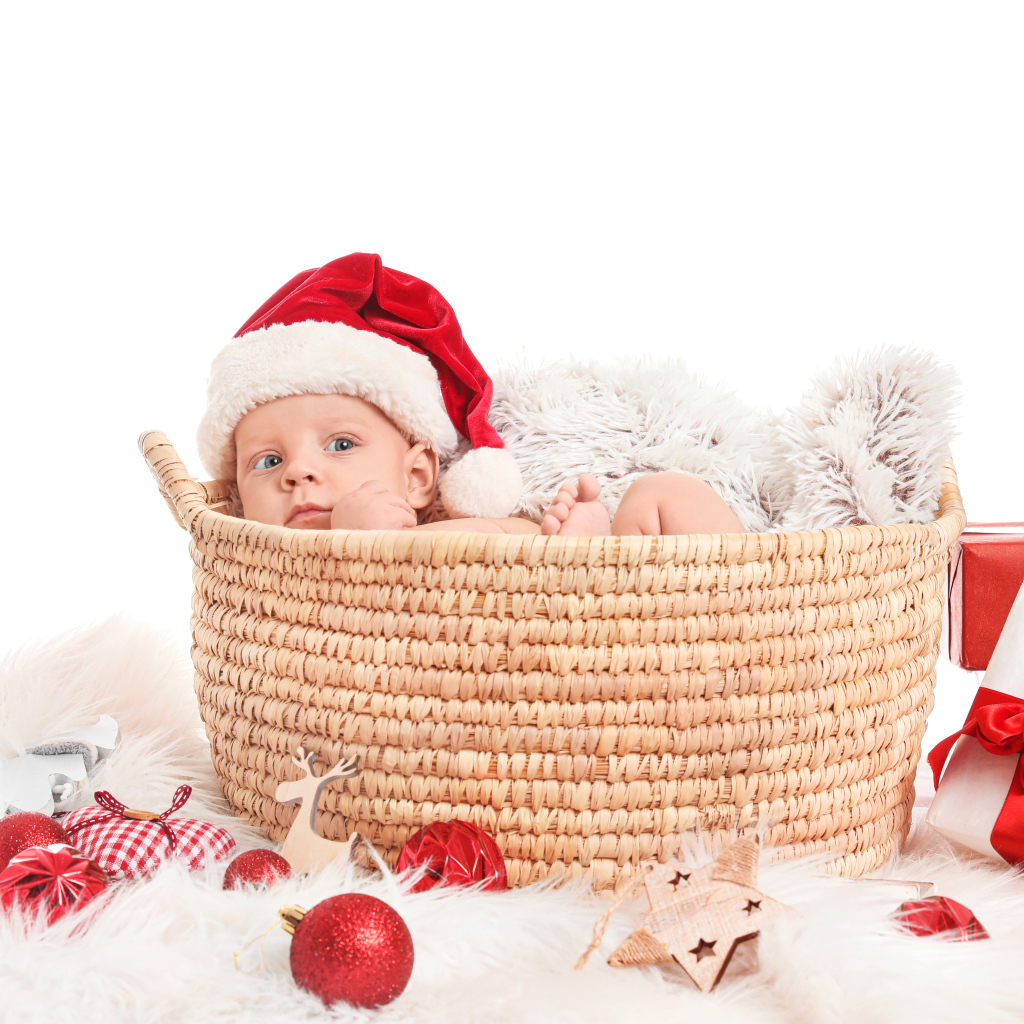 Маленький ребенок в корзине с подарками на новый год 