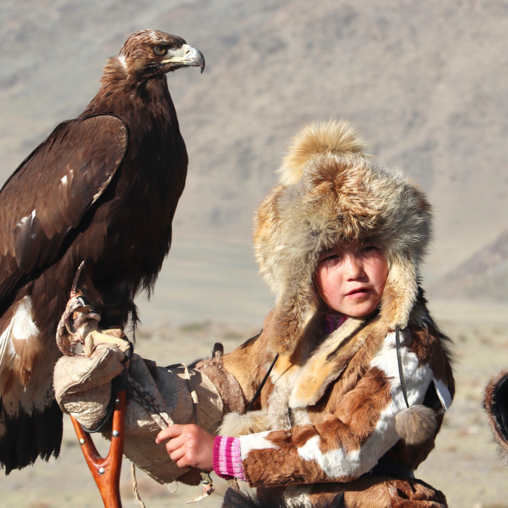 Маленький ребенок на охоте с хищным орлом