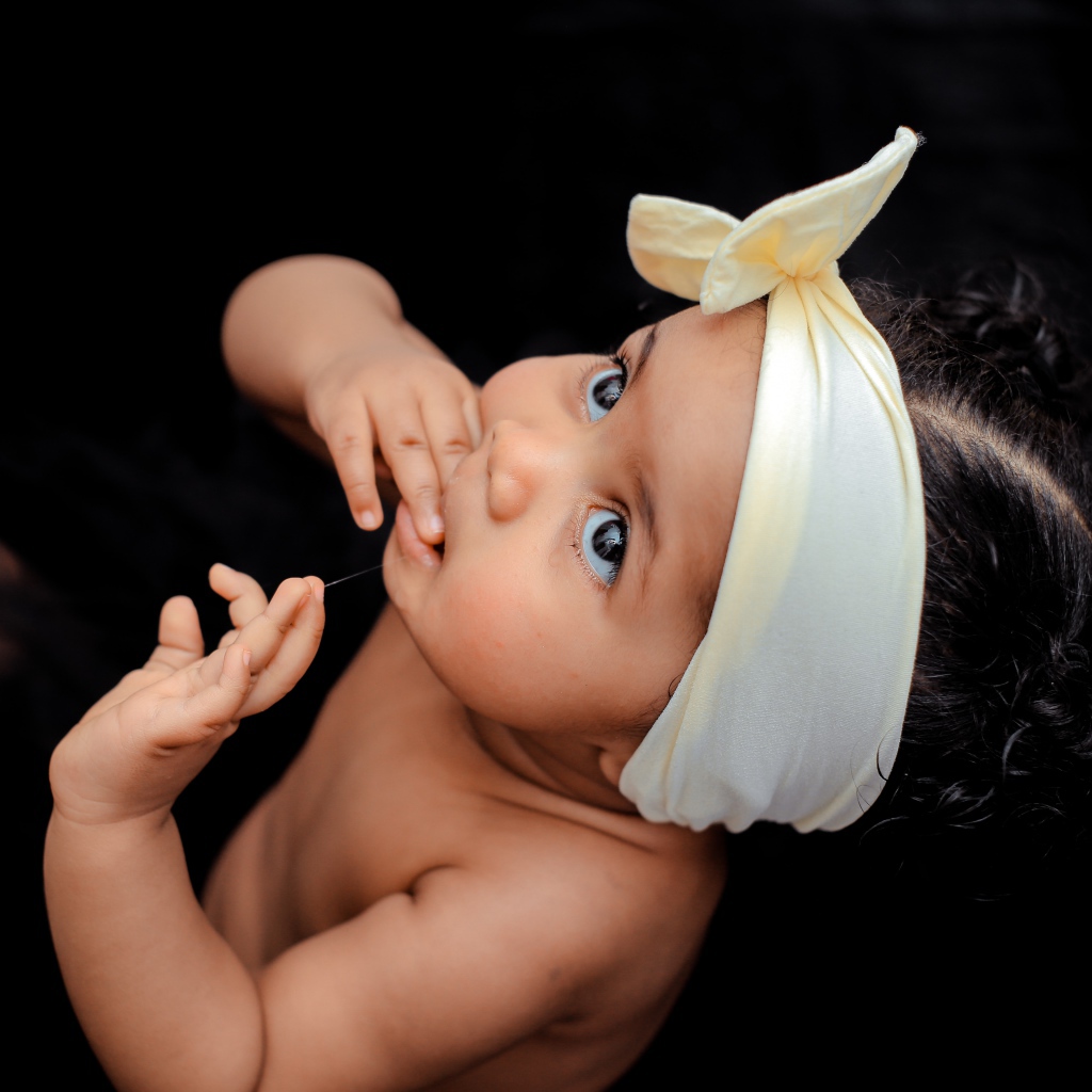 Маленькая темноволосая девочка с бантом на голове 