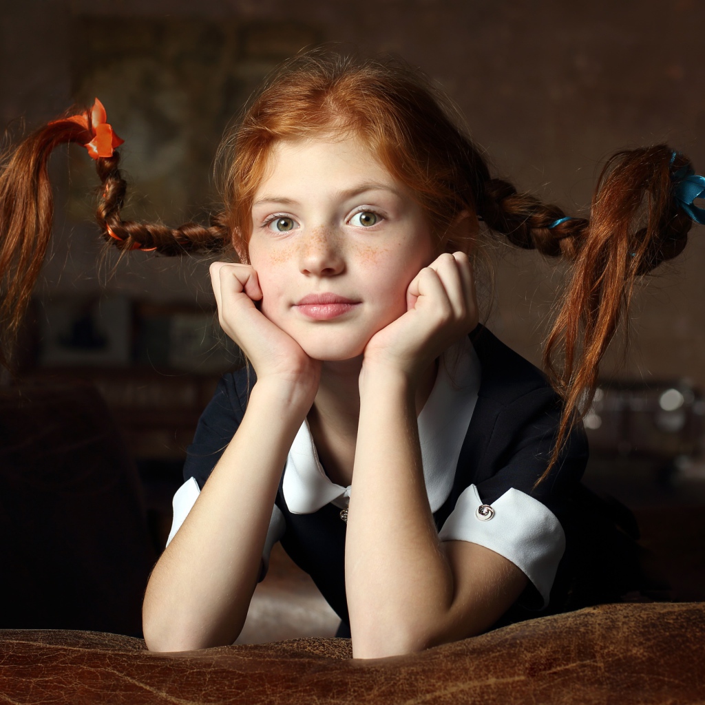 Маленькая смешная девочка с косами в школьной форме 