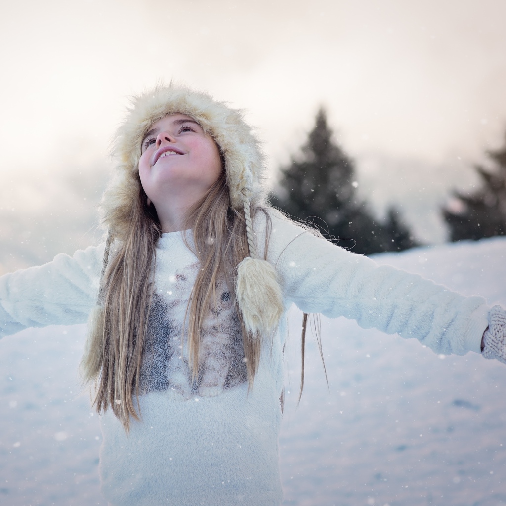 Маленькая девочка в теплой шапке на улице зимой