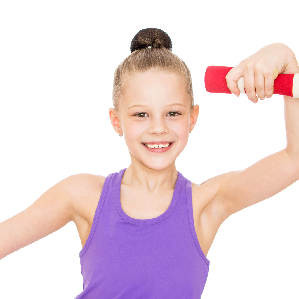 Маленькая девочка занимается с гантелей на белом фоне